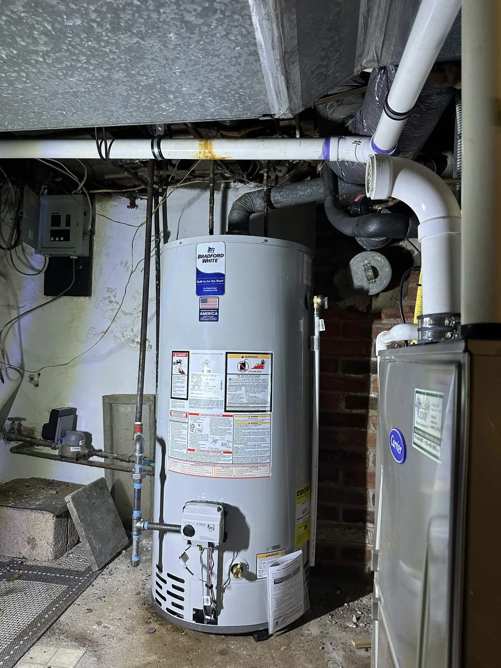 Gas water heater and its connections in a basement.