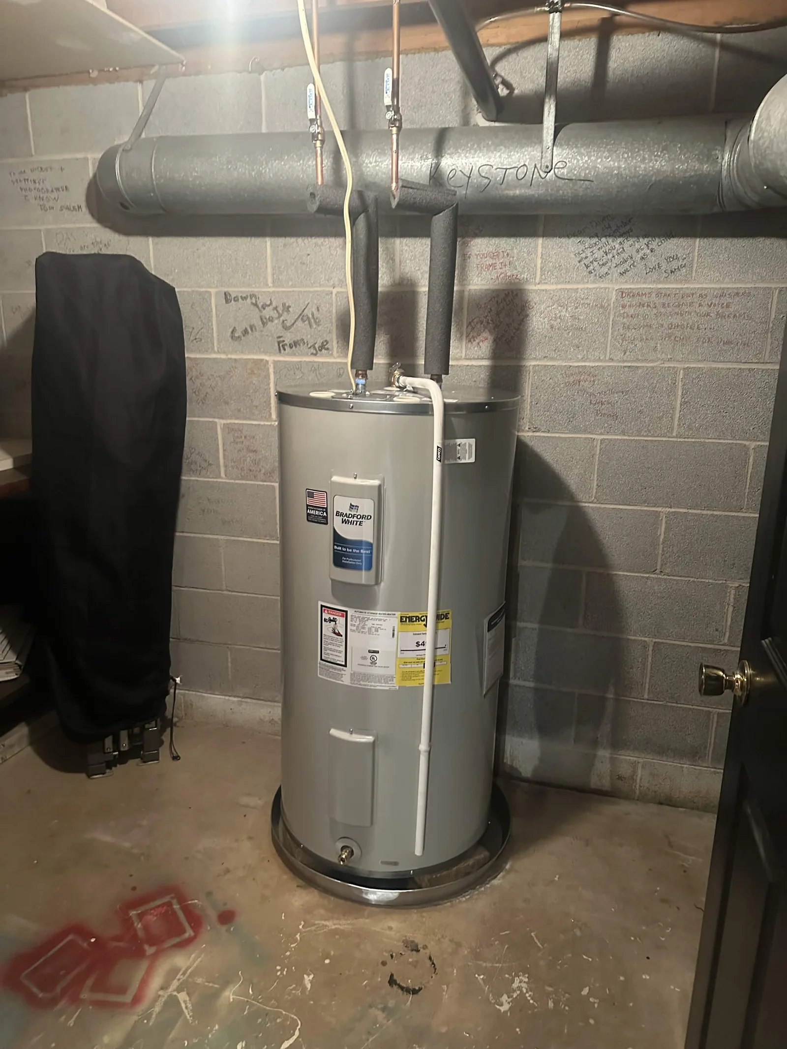 Electric water heater installed in a basement.