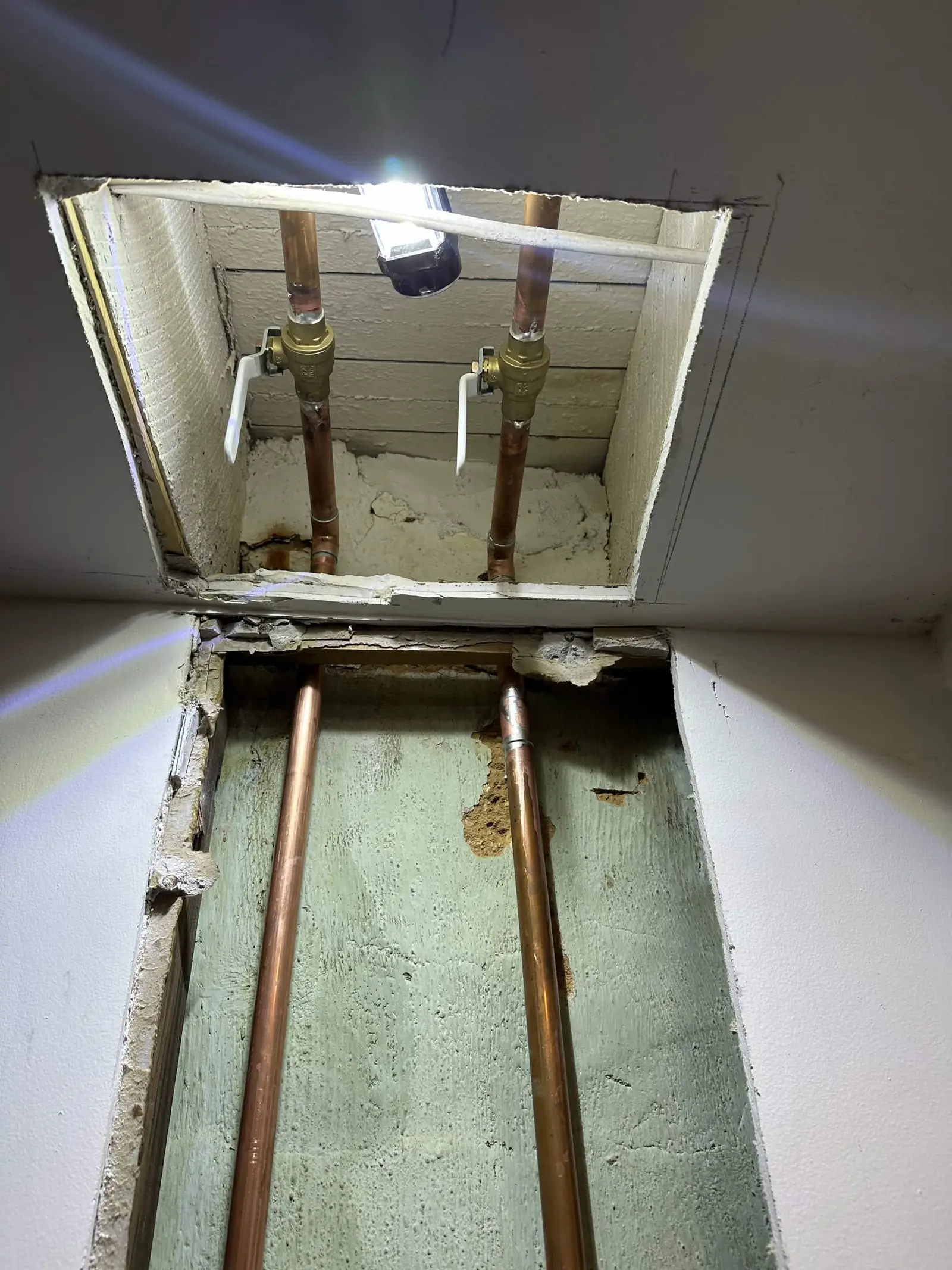 Copper piping and shutoff valves at the leak repair area.