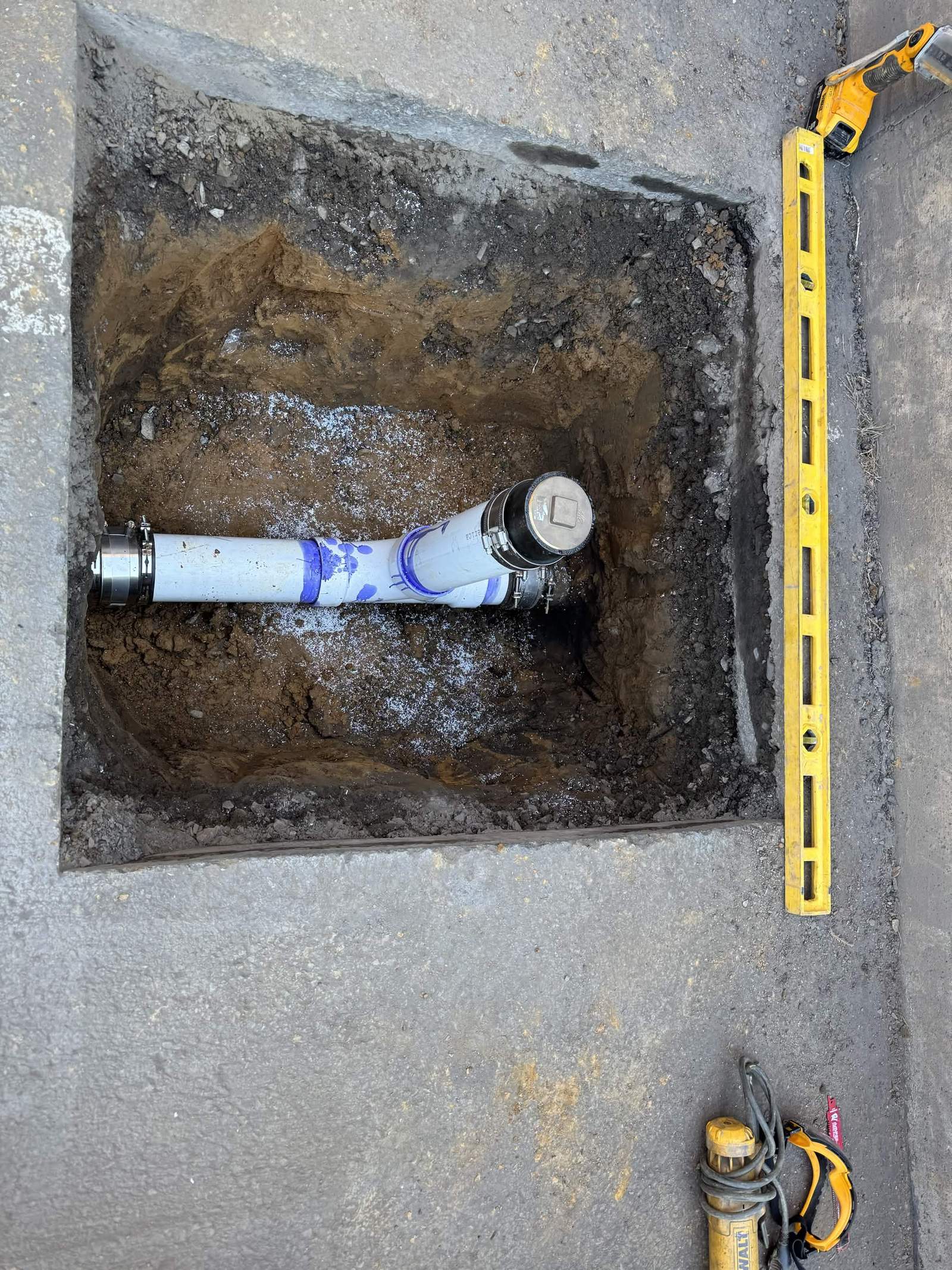 New sewer pipe and cleanout installed in an excavation.