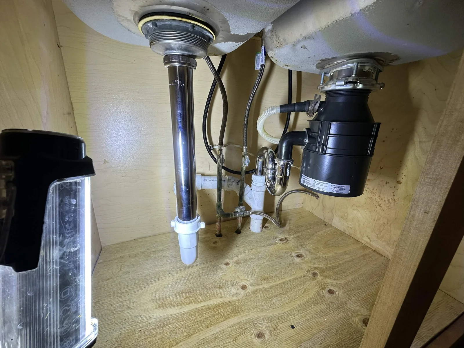 After: the cabinet base restored and sink drain and disposal reconnected.